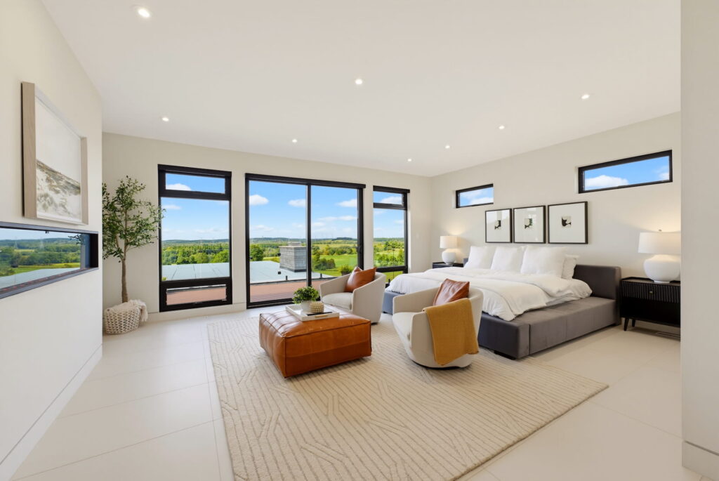 Principal bedroom with a seating area and wide windows onto the landscape