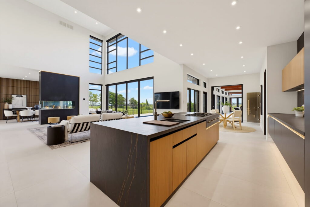 Open-plan kitchen with a dark stone island and double-height living area beyond