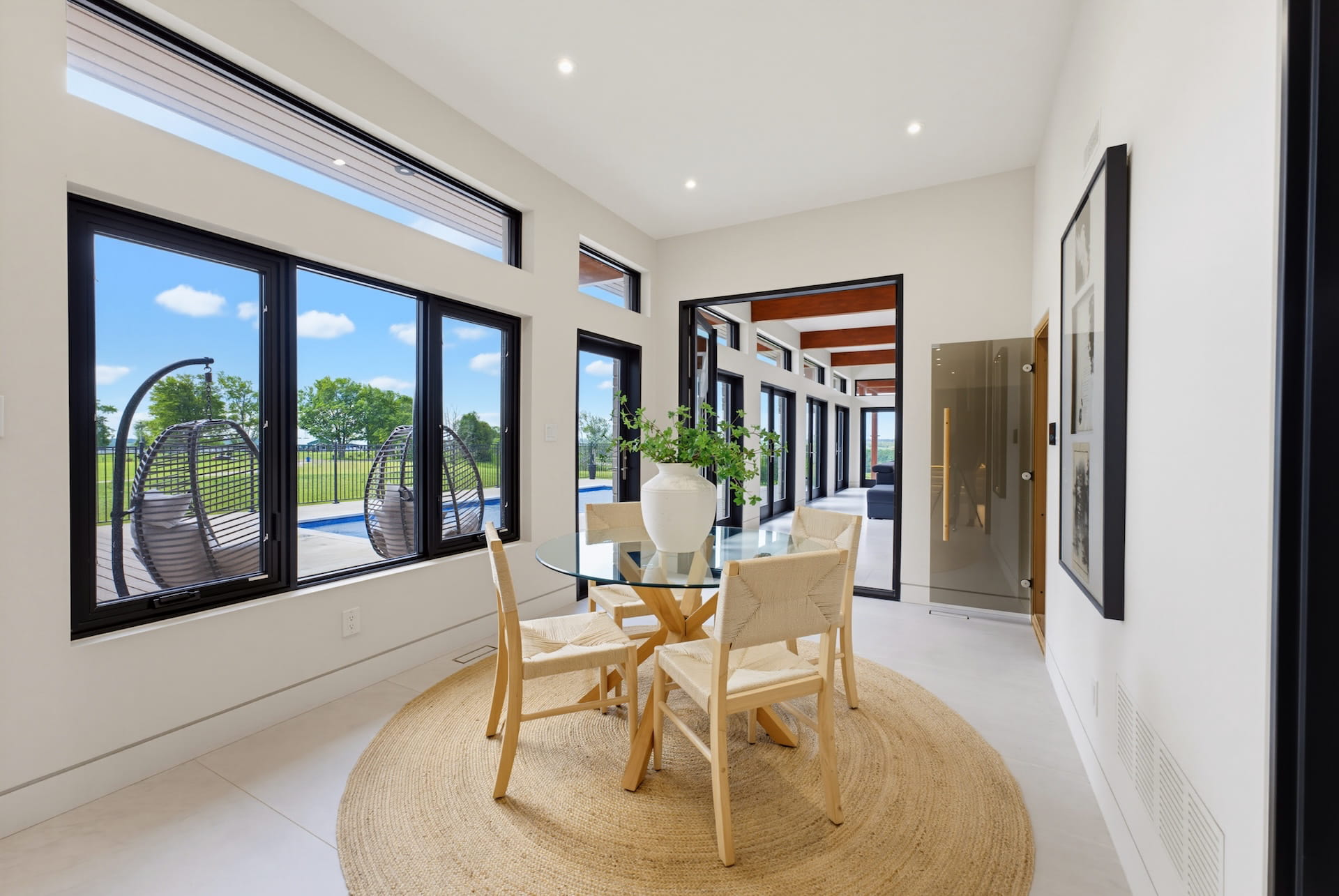 Bright breakfast area with a round table and full-height glazing onto the garden