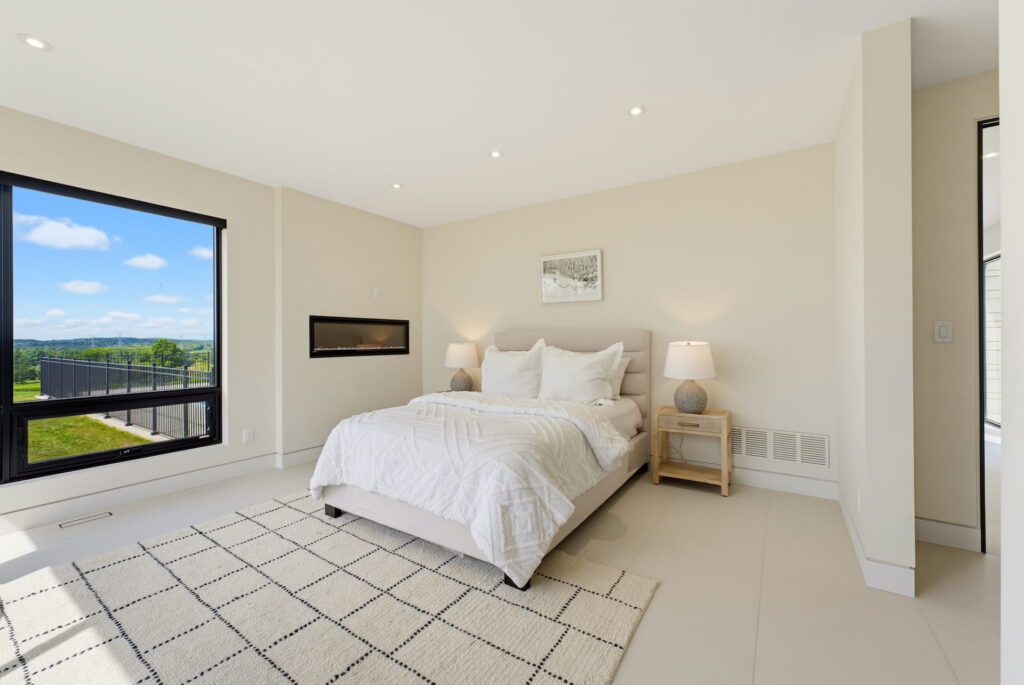 Principal bedroom with a picture window, linear fireplace and patterned rug