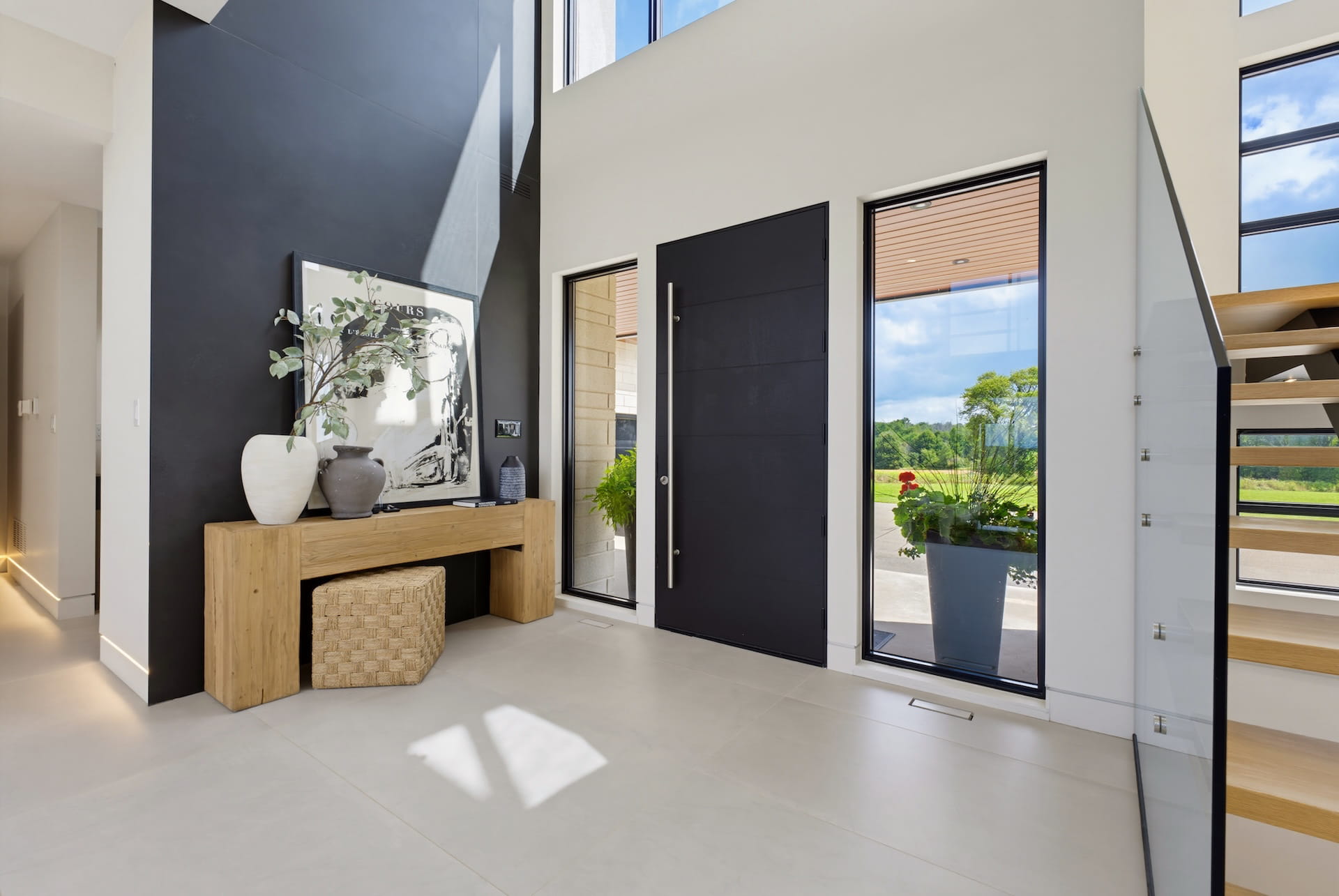 Double-height entry hall with an oak console and full-height glazed doors